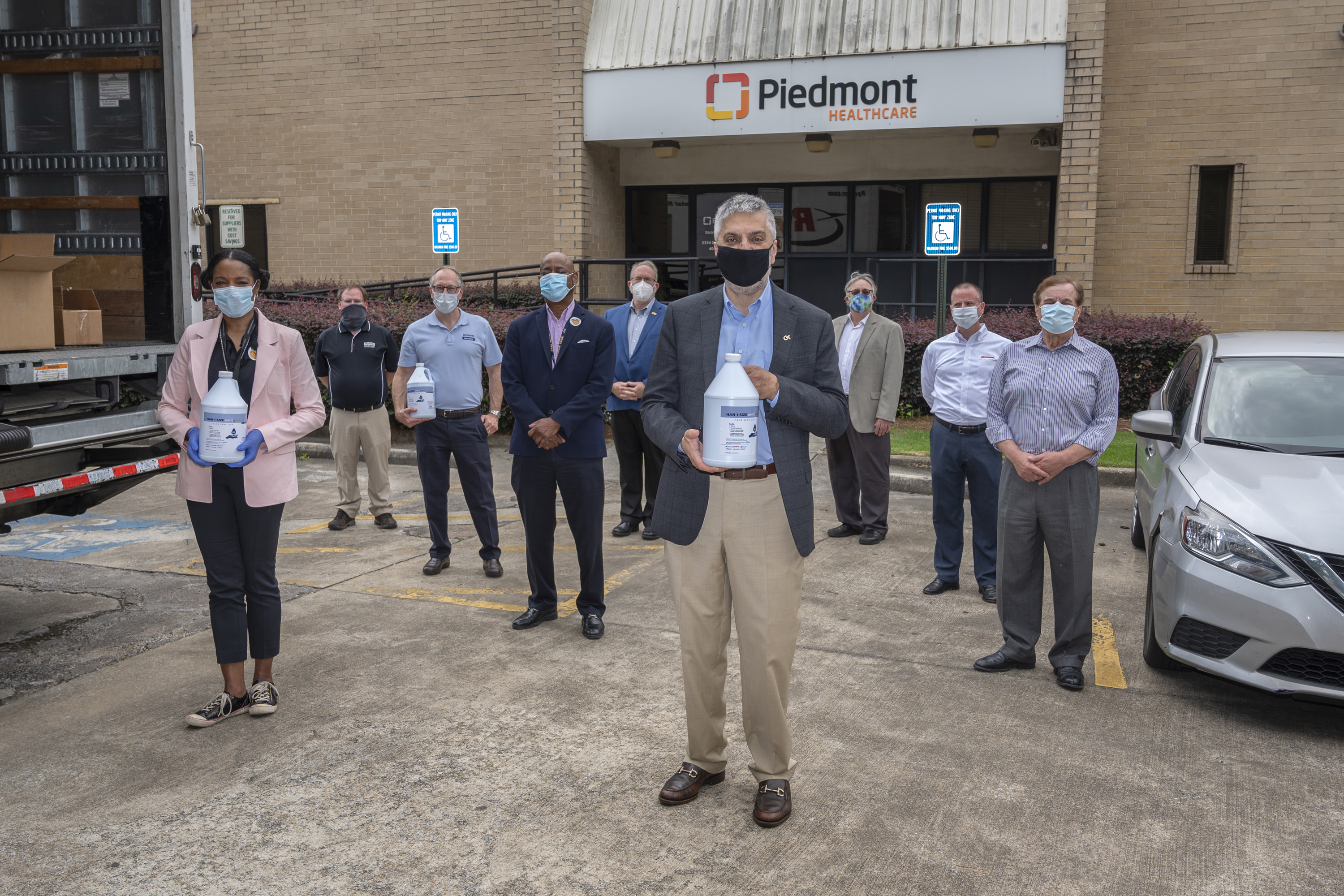 Here, many participants in the effort that re-made hand sanitizer using fuel-grade ethanol on its first day of delivery. The volunteers will donate 7,000 gallons of Han-I-Size White and Gold to hospitals and nursing homes across the country. In front, Dr. Chaouki Abdallah, Executive Vice President for Research, congratulates the group on its success. 