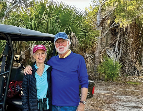 President Emeritus G. Wayne Clough and his wife, Mara Loftman, standing in front of subtropical vegetation including palm trees near the Georgia coast.